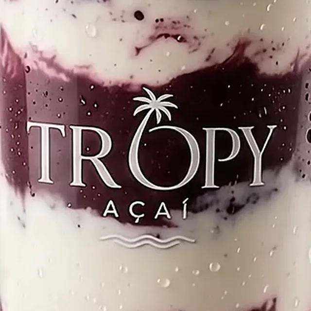 Detalle del vaso: el logo de Tropy Açaí impreso sobre las capas, con una palmera encima de la O.
